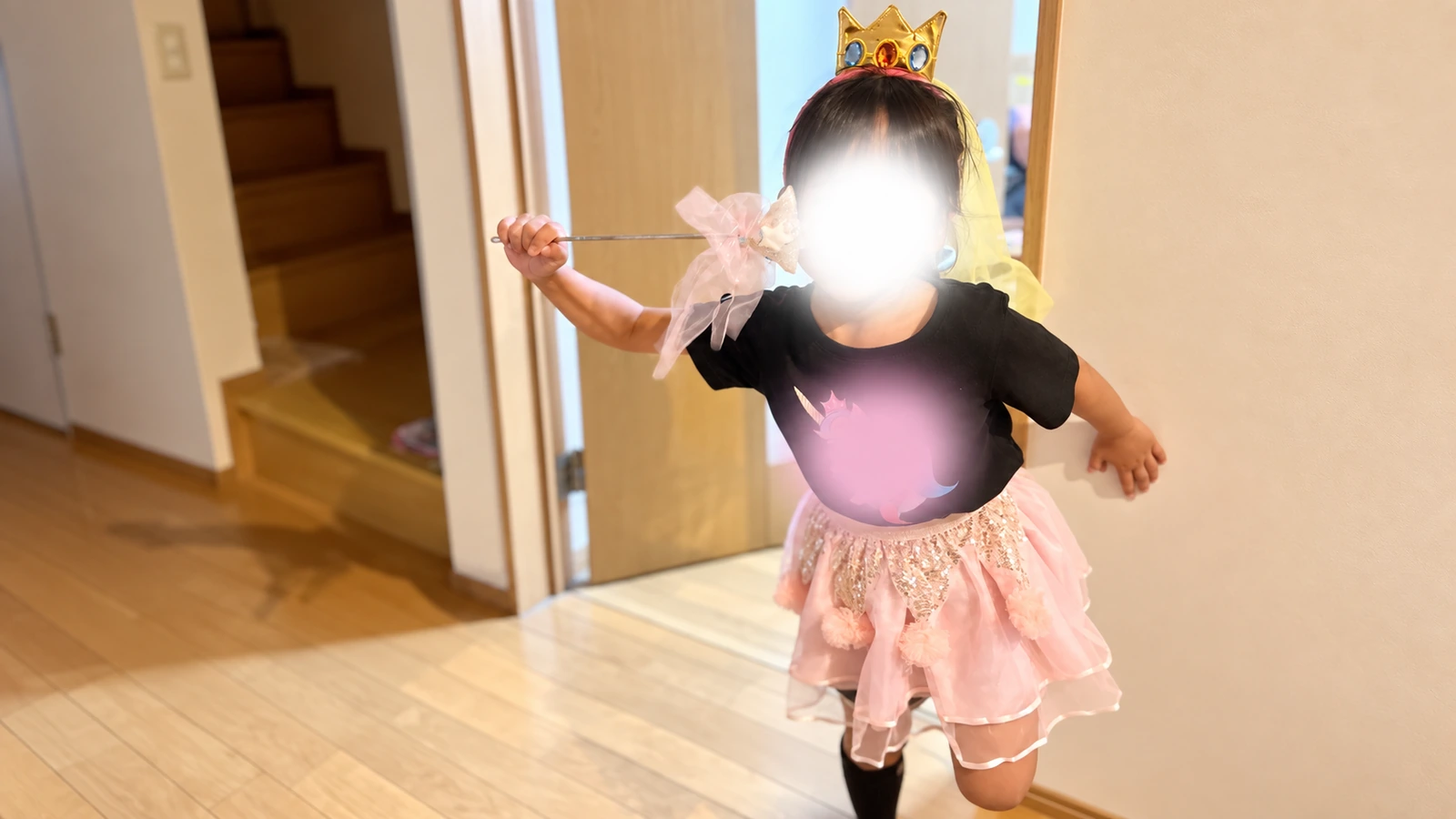 ハロウィンの仮装で王冠とピンクのスカートを身につけた子ども