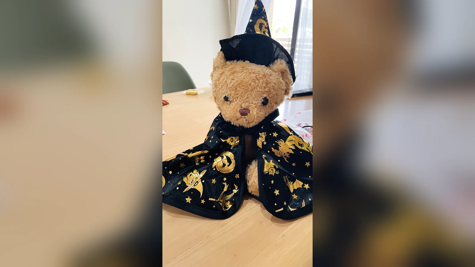 黒い魔法使いの帽子と金色の模様のマントを着たハロウィン仕様のテディベア